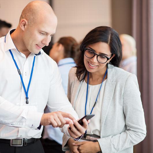 Man showing phone to woman at networking event